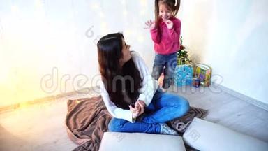 女姐姐和最小的女孩做发型，坐在地板上，墙上有花环和小杉